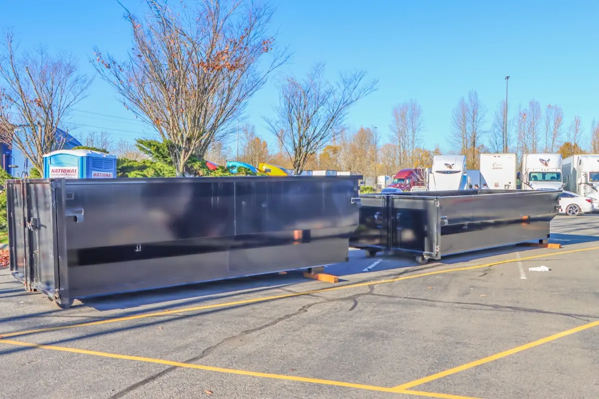 Professional dumpster rental service with roll-off container on residential driveway in West Milford